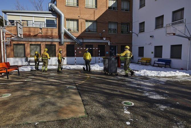 Militares de las Brigadas de Refuerzo de Incendios Forestales (BRIF) colaboran durante el segundo día de limpieza del hielo y nieve en las inmediaciones de un colegio, tras la gran nevada provocada por el paso de 'Filomena' por la región.