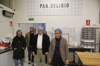 La comitiva ha recorrido el principal establecimiento de esta empresa, instalado en una antigua nave industrial, que alberga un obrador de 250 m2 abierto al público desde el ventanal de una tienda despacho, y en cuya planta superior aloja el gran aula de MATERIA, una escuela de panadería y repostería.