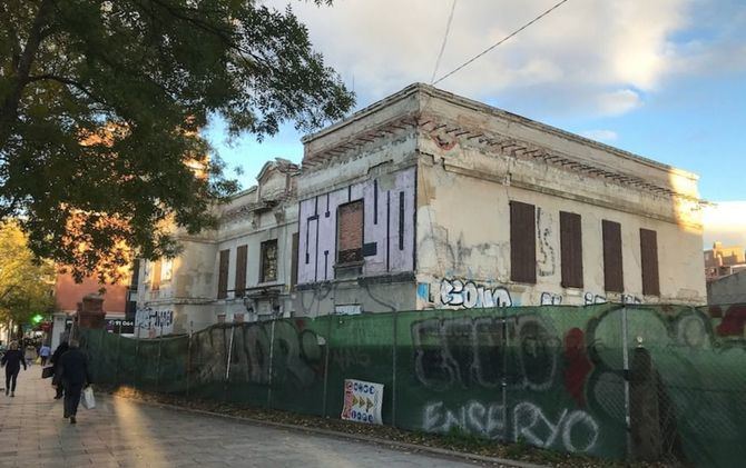 La gran fachada de la casa-asilo Goicoechea e Isusi, en el distrito de Carabanchel, producto de la reconstrucción realizada por Secundino Zuazo, aloja desde hace años grafitis multicolor y lo que antes era una vistosa tapia es ahora una pequeña valla de alambre, forrada con una lona verde, víctima también de las pintadas.