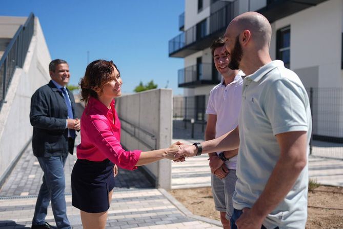 Los inmuebles de Tres Cantos visitados por la presidenta regional, se empezarán a entregar la próxima semana y a lo largo del verano. En la imagen, Diaz Ayuso, junto al consejero de VIvienda, Jorge Rodrigo, saludan a Guillermo y Adrián, dos de los adjudicatarios de la nueva promoción del Plan Vive en este municipio madrileño.