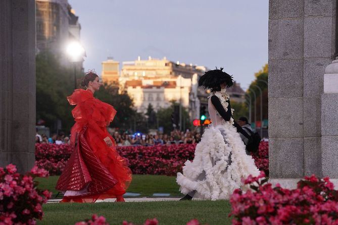 El acto ha convertido la icónica Puerta de Alcalá en una pasarela al aire libre sobre la que 50 modelos han lucido las creaciones de 28 diseñadores, inspiradas en la tradición, el folklore y la artesanía de la ciudad.