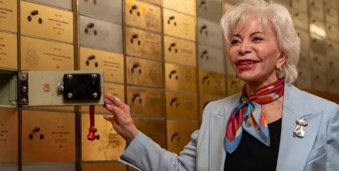 Isabel Allende posa ante el cajetín número 989 de la Caja de las Letras del Instituto Cervantes, tras depositar su legado. 
