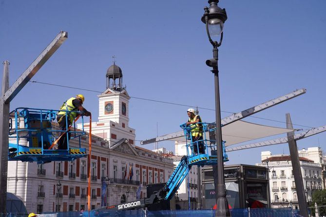 Tras la adecuación de los bancos y la instalación de los anclajes en las fachadas y de los mástiles en los bancos, hoy ha comenzado la colocación de las telas sobre la estructura.