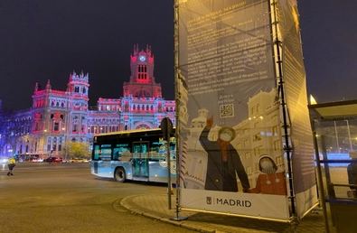 El ángel del edificio Metrópolis de la Gran Vía llena de ilusión la ciudad de Madrid en el instante que llega la estrella de Oriente ante la mirada de un abuelo que pasea con su nieta, cada uno con su mascarilla. Es el cartel ilustrado por Asia Orlando, que podemos ver en numerosos espacios de la ciudad durante las fiestas.