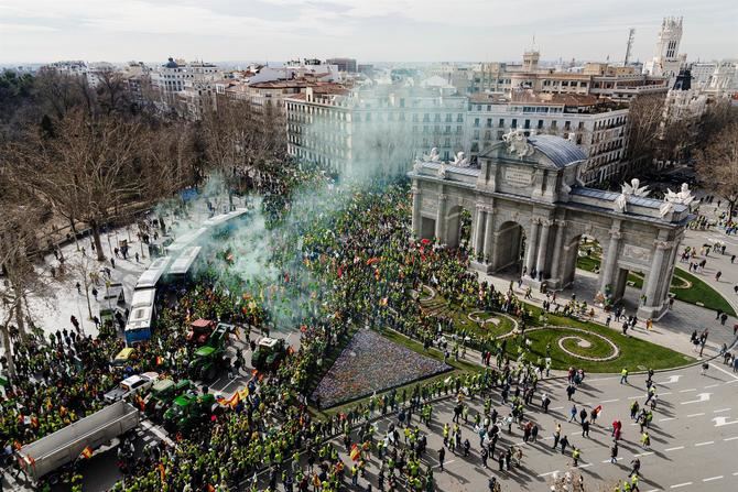 En la imagen, cientos de agricultores reciben a las primeras columnas de tractores en la Puerta de Alcalá durante la décimosexta jornada de protestas de los tractores en las carreteras españolas.