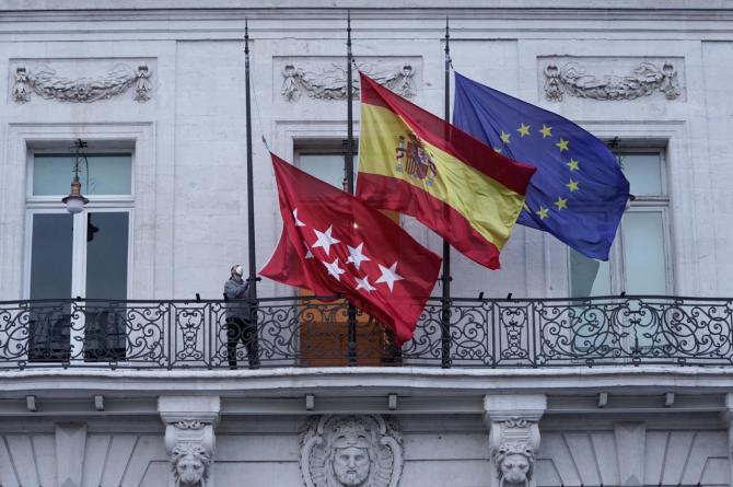 Banderas a media asta en el balcón de la Real Casa de Correos.