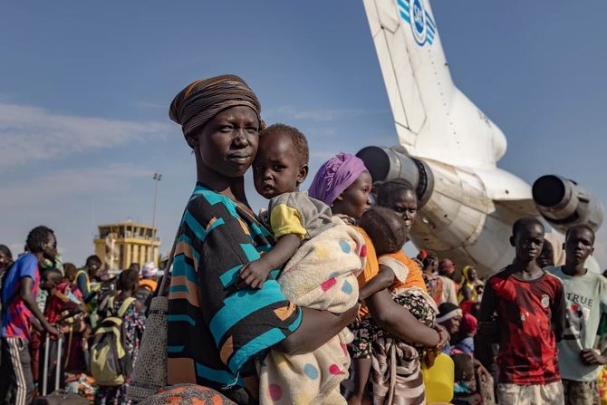 Achol Deng y su hija esperan junto a cientos de personas refugiadas sursudanesas que regresan al aeropuerto de Palouch, en el estado sursudanés del Alto Nilo, después de huir del conflicto en Sudán.