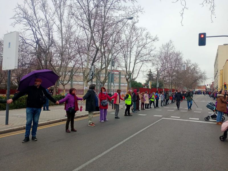 Cadena humana ante el mural feminista por el 8M 2023